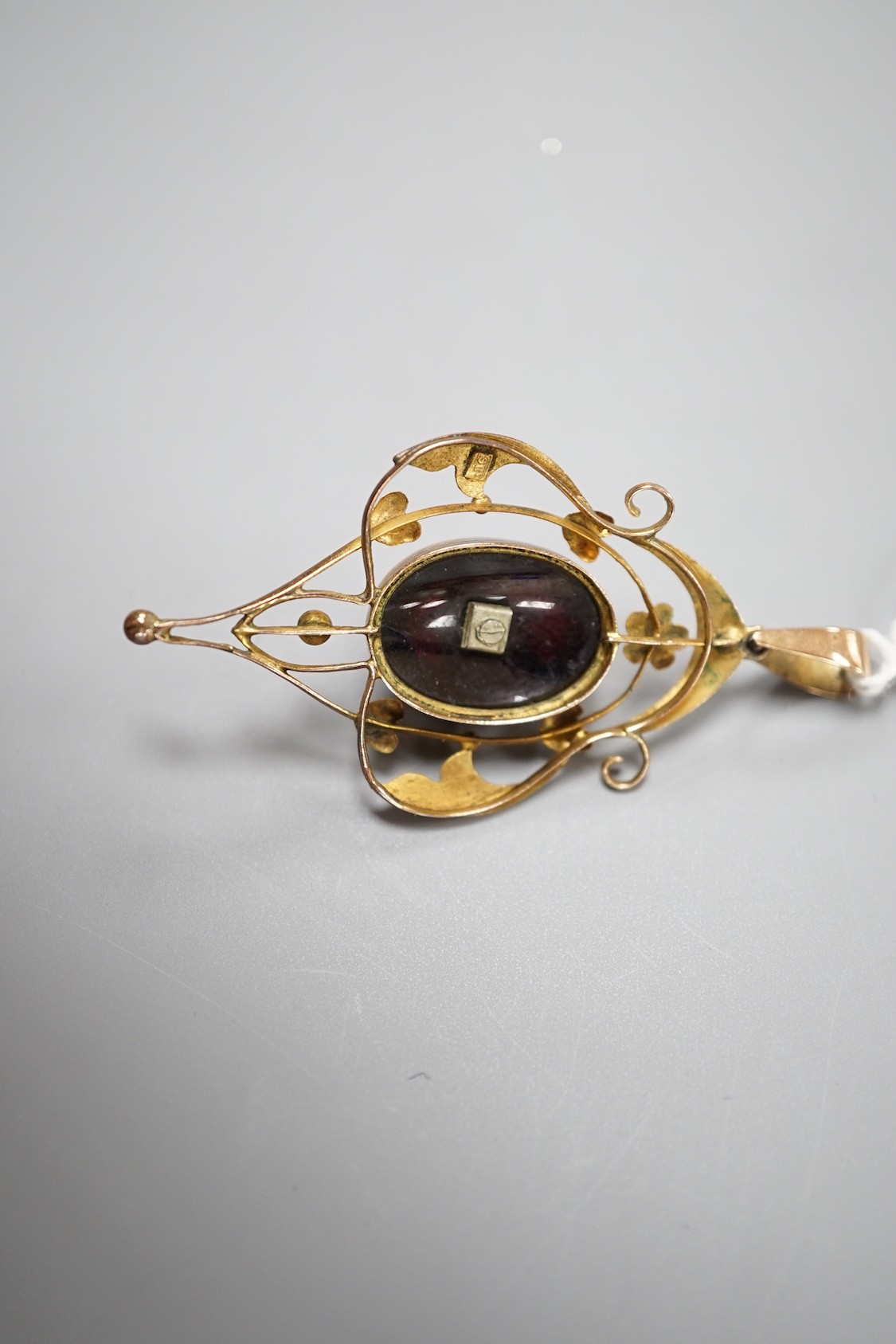 An Edwardian Art Nouveau 9ct, garnet, split pearl and diamond set pendant, overall 57mm, gross weight 6.8 grams.